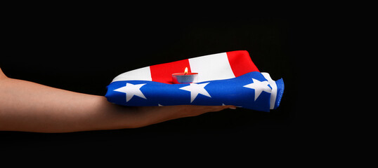 Woman holding burning candle with USA flag on black background. National Day of Prayer and...