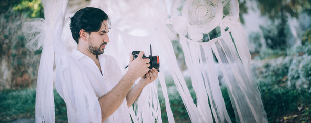 A young man - a videographer, a photographer at a wedding at work with a camera in his hands.