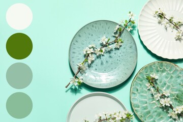 Beautiful table setting with blossoming branches on turquoise background. Different color patterns