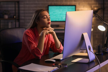 Tired female programmer working in office at night