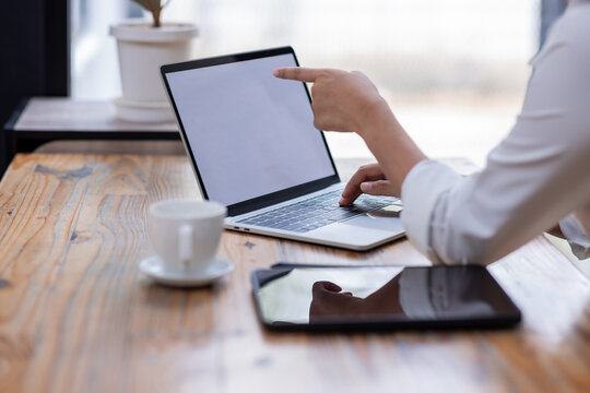 Closeup of hands typing on a laptop keyboard, Freelancer working on laptop at desk in loft office