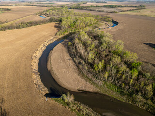 Little Nemaha River is meandering through Nebraska farmland near Brock, springtime aerial view