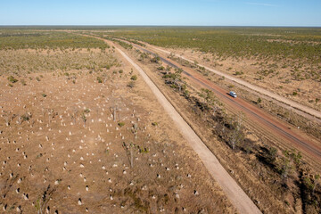 Outback road passing through giant termite ant mounds in Queensland, Australia.