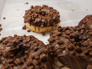 Chocolate Glazed Donut with Toppings on White Background