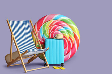 Deck chair, swimming mattress, suitcase and beach accessories on color background