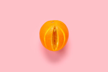 Fresh cut orange on pink background. Sex education