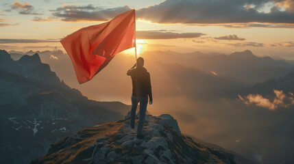 A man is standing on a mountain holding a red flag
