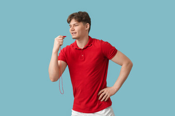 Male lifeguard with whistle running on blue background