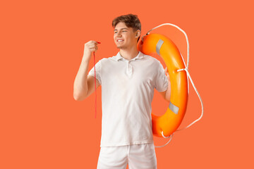 Male lifeguard with ring buoy and whistle on orange background