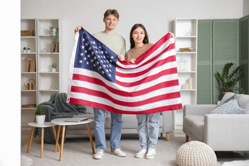 Young couple with flag of USA at home