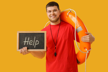 Young male lifeguard holding ring buoy and chalkboard with text HELP on yellow background