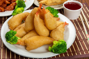 a heaping plate of Chinese breaded shrimp with dipping sauce and chop sticks