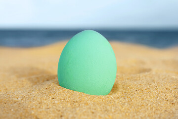 Festive painted Easter egg on sea beach