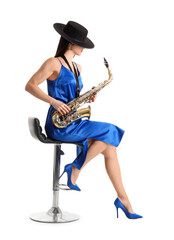 Beautiful young woman with saxophone sitting on white background