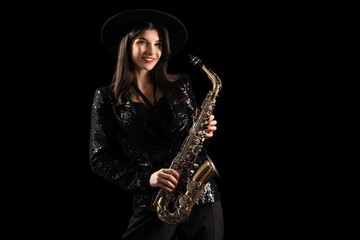 Beautiful young woman with saxophone on dark background