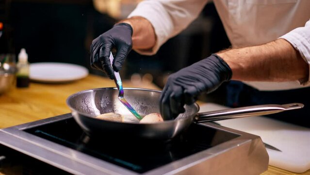 close-up of two pieces of transverse fish fillet lying on professional hot frying pan