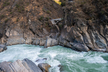 An old bridge opposite the landscape of Tiger Leaping Gorge in Yunnan province of China.