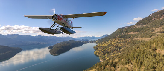 Floatplane flying over Canadian Lake and mountain landscape. Aerial BC, Canada