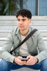 portrait of young confident man with smartphone