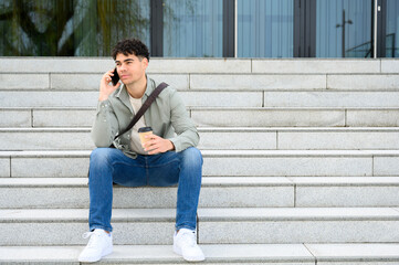 portrait of young man talking on phone, enjoying a coffee