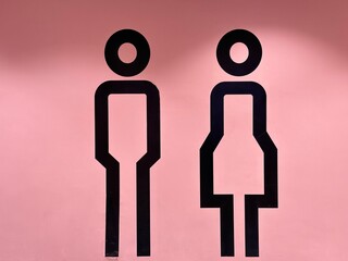 male and female toilet sign on pink background
