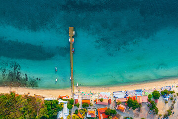 Aerial top view of colorful umbrellas on sandy beach, swim in blue sea summer sunny day. Tropical...