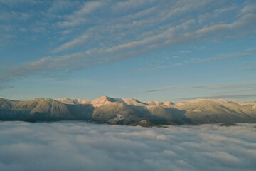 Aerial view of beautiful mountains above clouds