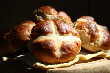 Tasty hot cross buns on table against dark background, closeup