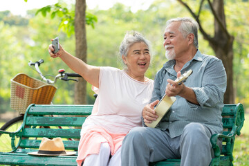 senior couple taking photo or selfie from smartphone in the park