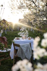 Stylish table setting with beautiful spring flowers in garden