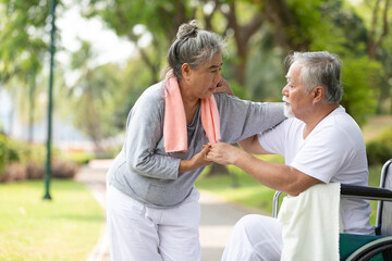 senior woman helping and holding hands her husband in the park