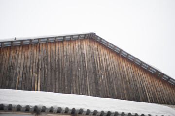 Roof made of planks. Snow on the roof. Building details.