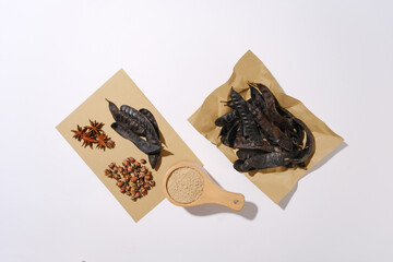 White background against vintage brown paper with some medicinal herbs above including star anise,...