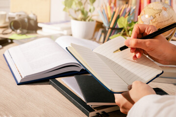 The educational concept: a hand is writing with a pen on a notebook
