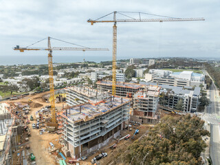 Aerial view of new dorm complex construction site with yellow cranes at the University of California San Diego 