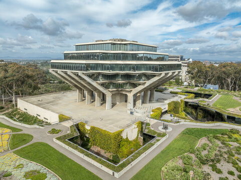 Aerial view of Geysel library at the University of California San Diego, futuristic building, columns holding up upper floor like books, next to the snake path