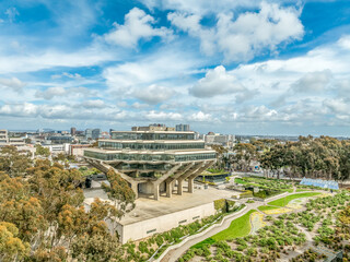 Aerial view of Geysel library at the University of California San Diego, futuristic building, columns holding up upper floor like books, next to the snake path