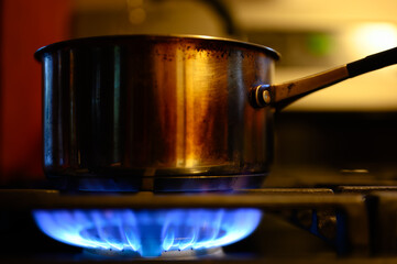Natural gas burner at a cabin kitchen heating up a metal pot.