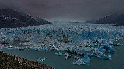 The incredible Perito Moreno Glacier stretches to the horizon between the mountain slopes. A mass...