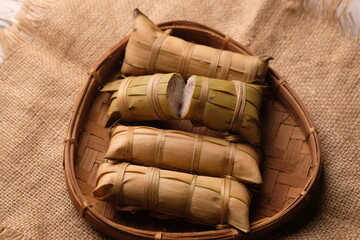 Lepet is a snack made from sticky rice and grated coconut and seasoned with salt, wrapped in young...