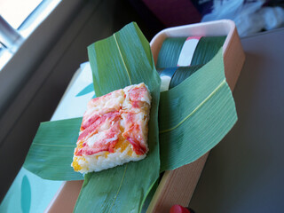 Kani Crab oshizushi or pressed sushi with Tobiko caviar wrapped in bamboo leaf, train catering food