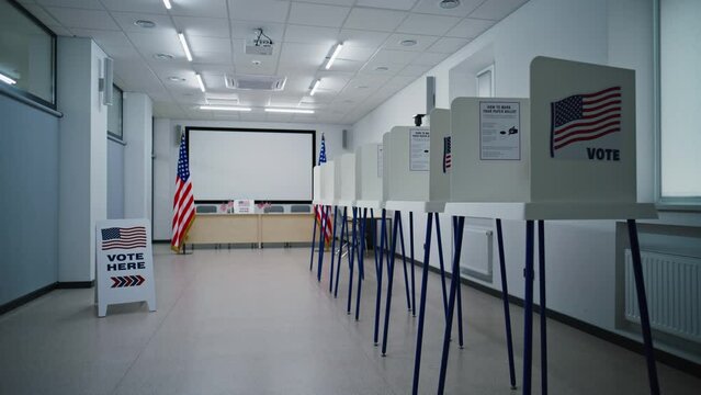 Voting booths with American flag logo in polling station office. The lights turn on. Start of the National Election Day in the United States of America. Political races of US presidential candidates.