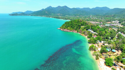 Captivating aerial shot reveals a tropical sea's beauty, a symphony of vibrant blues and lush...