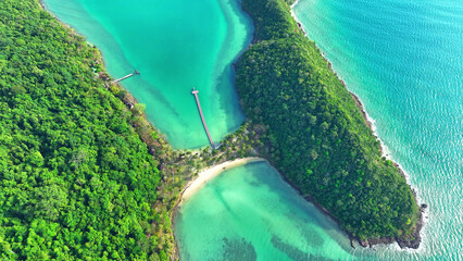 Turquoise waters surround a stunning tropical island seen from above, boasting a sandy beach...