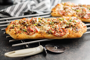 Tasty italian square pizza on kitchen table.