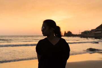 Beautiful young Indian woman Enjoying the beautiful sunset at Goa Beach in India. Delightful girl...