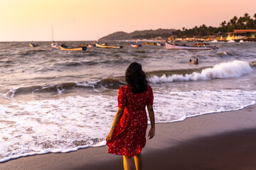 Happy beautiful young Indian woman enjoying sunset at the Goa beach. Delightful girl enjoying...
