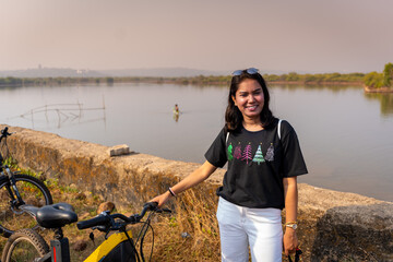 Young indian woman relaxing after bycycle ride at Divar Island in Goa, india