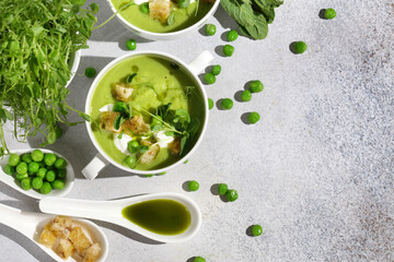 Cool Summer Pea Soup with Croutons, Sour Cream, Fresh Mint, Pea Sprouts, and Parsley Green Oil. Vegetarian Cuisine Idea. Copy Space. Artisanal Photography, Not AI