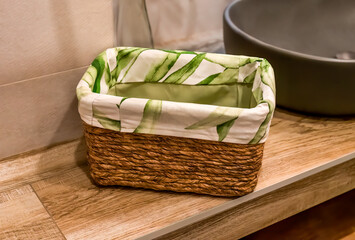 wooden wicker basket with towels on wooden shelf for bathroom